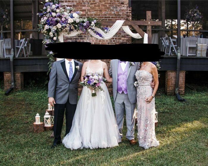 Grupo en una boda con decoración floral y atuendos formales, posando al aire libre.