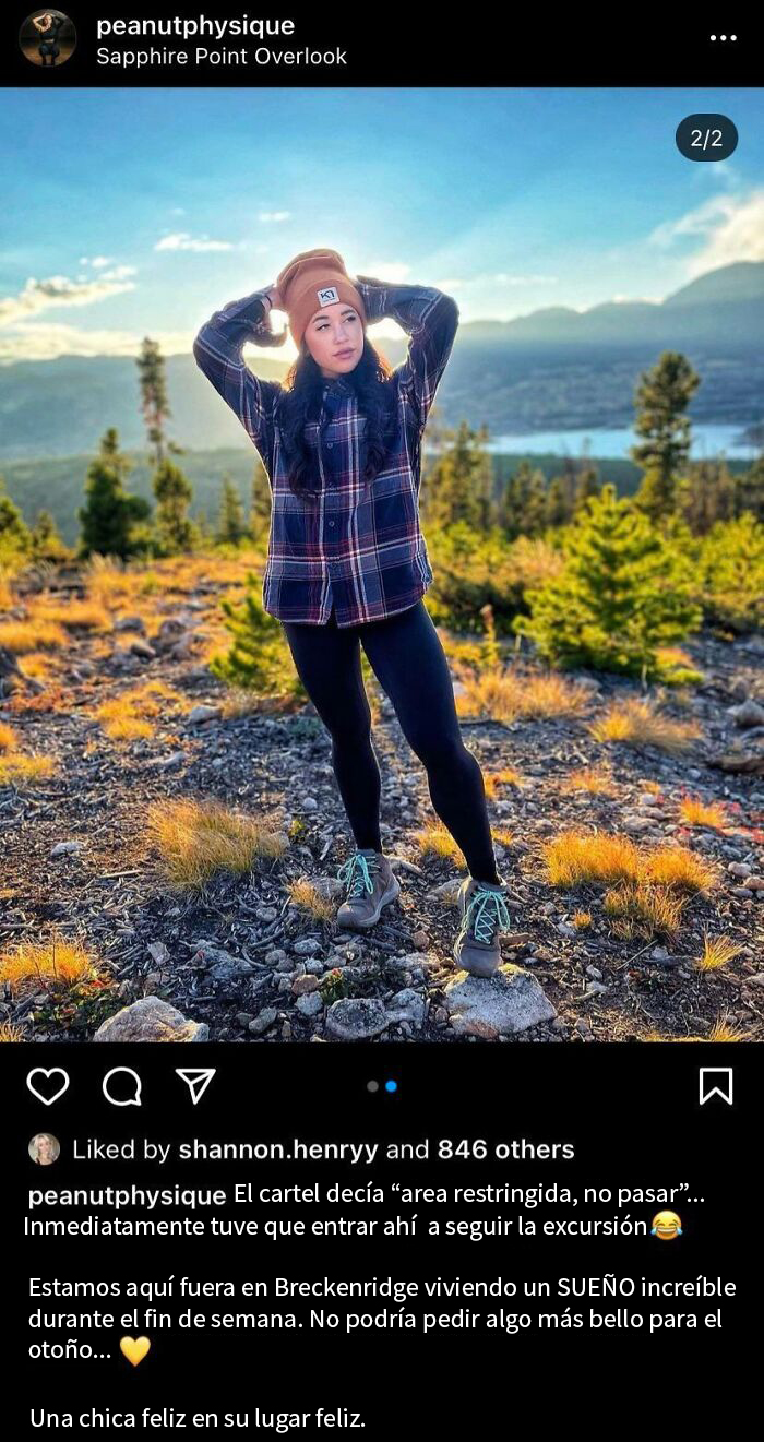 Influencer posando en un paisaje montañoso con atuendo casual.